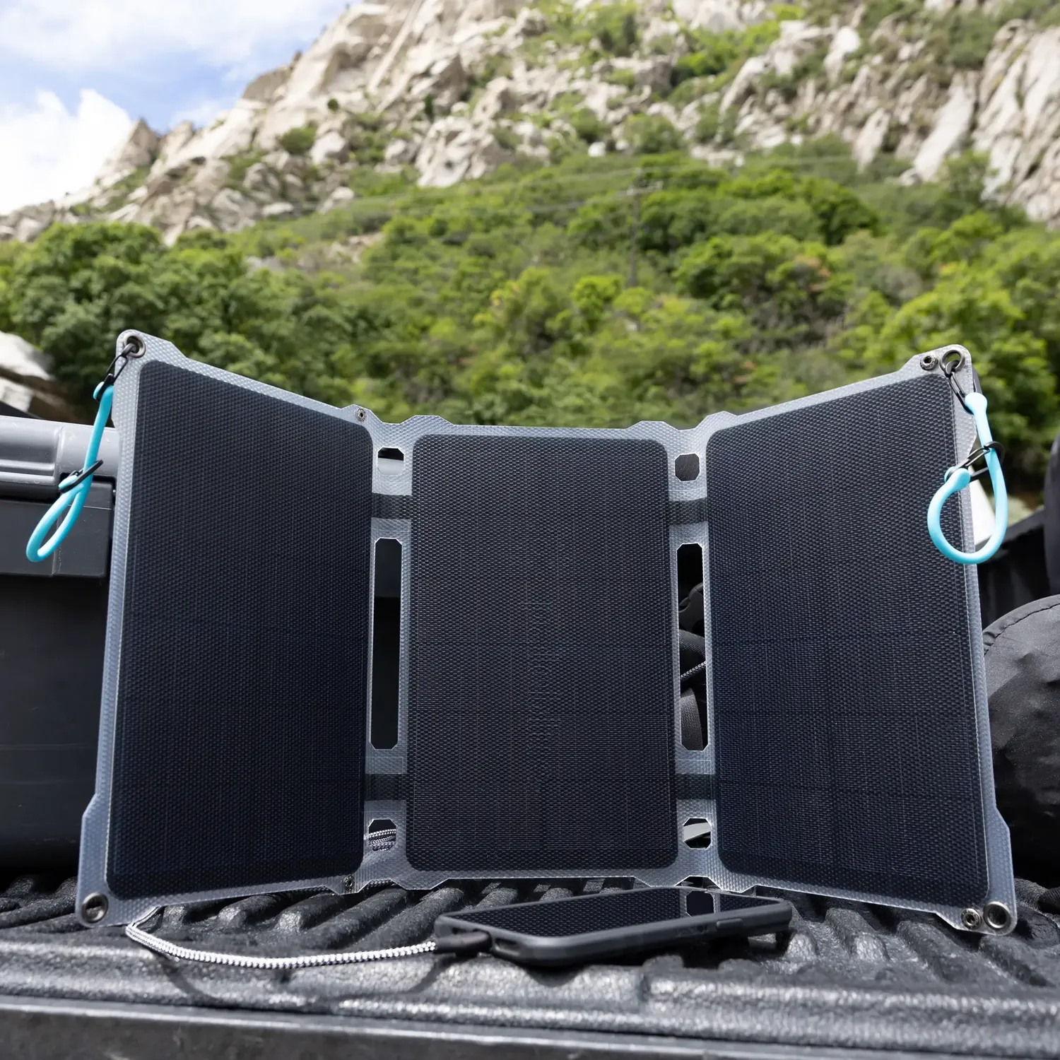 Paleblue Approach 2 Triple-Panel Solar Charger opened on a truck bed in the sun, all three panels facing up.