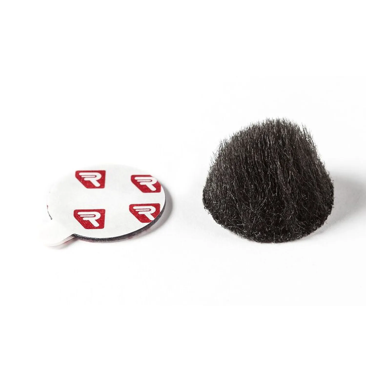 Rycote Overcovers Advanced: A black Overcovers Advanced fur disc beside a sheet of round Stickies.