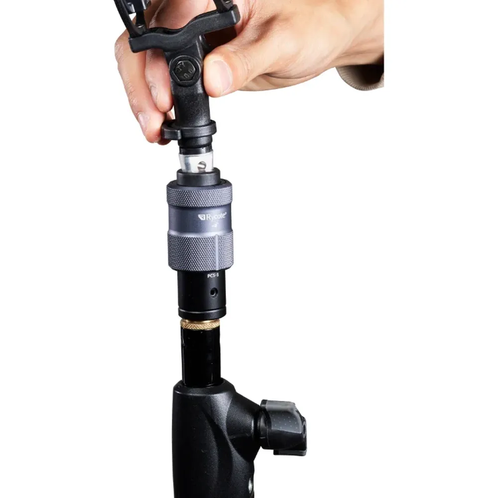 Rycote PCS Spigot on a microphone stand as a hand clicks a mic mount into it from above.