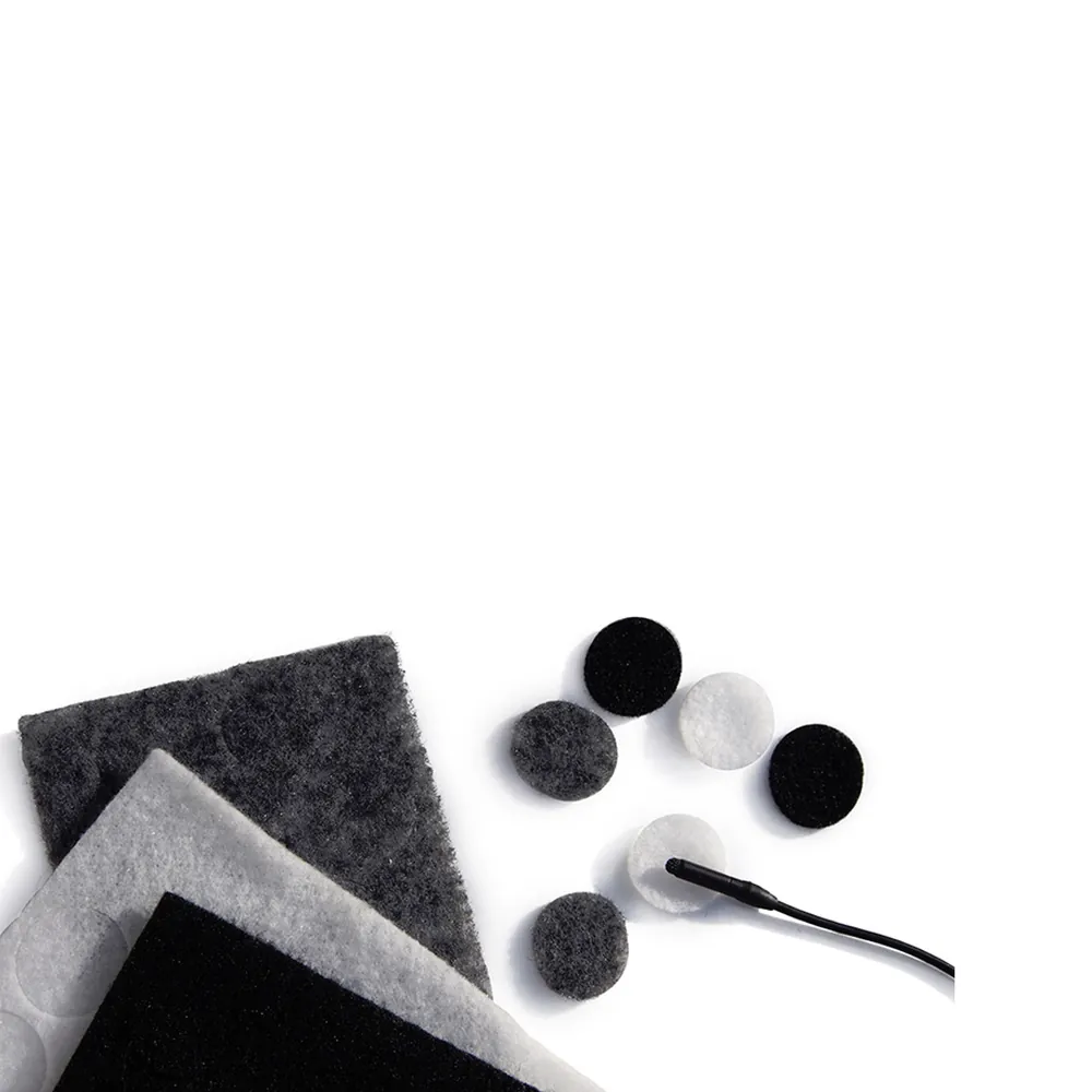 Rycote Undercovers Fabric Discs for Lavalier Mics: Fabric squares and discs in black, gray, and white beside a lavalier mic.