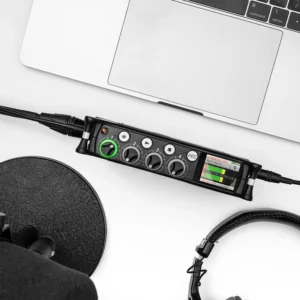 Sound Devices Reporter Plugin: A MixPre on a desk beside headphones and a laptop.